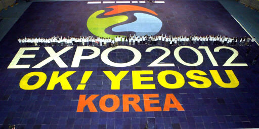 <b>2012명이 맞춘 여수박람회 퍼즐</b> 전국의 참가자 2012명이 지난 1일 서울 올림픽체조경기장에서 기네스 세계 기록에 도전하기 위해 2012개의 조각의 퍼즐로 ‘2012 여수세계박람회’ 엠블럼을 맞춘 뒤 환호하고 있다. 여수시 제공
