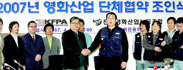 18일 오후 서울 동대문구 영화진흥위원회 소회의실에서 열린 ‘2007 영화산업 단체협약 조인식’에서 영화제작가협회 차승재 회장과 최진욱 영화노조 위원장이 교섭을 마치고 악수를 하고 있다.(사진 가운데 왼쪽부터) 연합뉴스