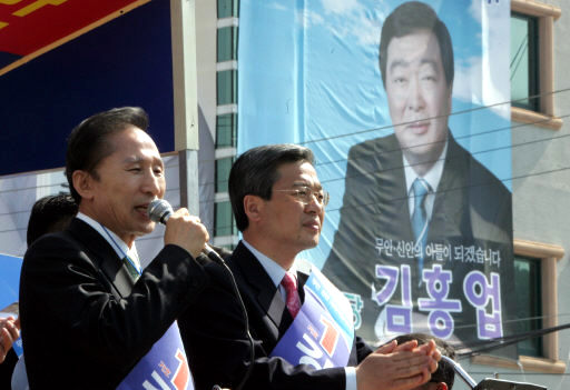 4·25 재·보선 지원유세를 위해 전남지역을 방문한 이명박 전 서울시장이 19일 전남 무안군 무안읍 장터에서 한나라당 후보를 지지해줄 것을 호소하고 있다. 이 지역에 출마한 김대중 전 대통령의 차남 김홍업 후보의 선거 현수막이 오른쪽에 내걸려 있다. 무안/김종수 기자<A href="mailto:jongsoo@hani.co.kr">jongsoo@hani.co.kr</A>