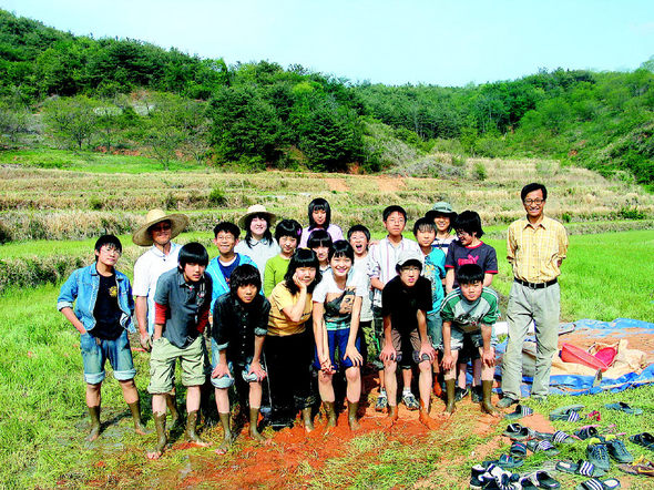 지난달 26일 공동체에서 만든 대안학교 민들레학교 학생과 교사들이 노작수업 시간에 모판을 만들다 김인수 대표(오른쪽)와 함께 포즈를 취했다.