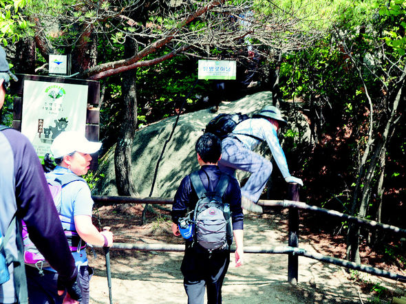 일요일인 지난 13일 서울 북한산 비봉을 오르려는 많은 등산객들이 암벽 위에서 줄을 서 기다리고 있다. 비봉과 근처 향로봉은 올라가기 위험해 출입이 금지돼 있지만 등산객들이 ‘탐방로 아님’이란 팻말을 보면서도 울타리를 아무렇지도 않게 넘고 있다.