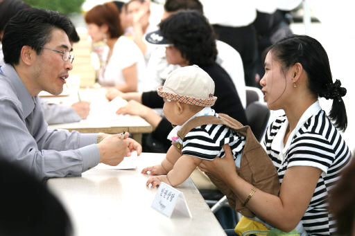 15일 충남 홍성에서 열린 국가인권위 순회상담을 찾은 한 결혼이민여성이 조사관에게 교육비 지원에 대해 문의하고 있다.