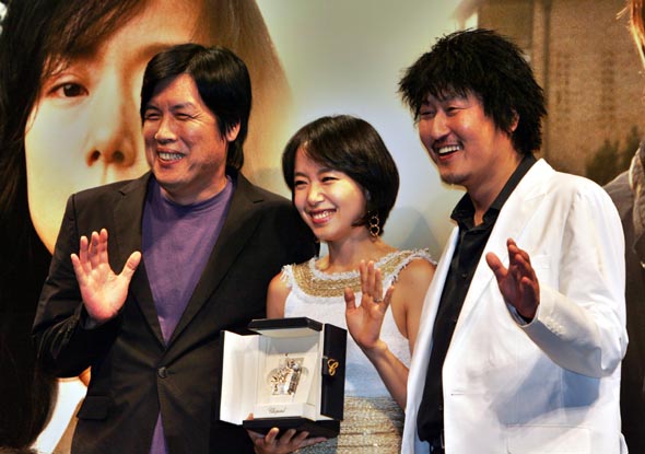 제60회 칸 국제영화제에서 이창동 감독(왼쪽)의 영화 <밀양>으로 여우주연상을 탄 영화배우 전도연(가운데)씨와 상대배우 송강호씨가 30일 오후 서울 강남 압구정동 씨지브이에서 열린 기자회견에서 수상패를 들고 취재진을 향해 손을 흔들고 있다. 
이종근 기자 <A href="mailto:root2@hani.co.kr">root2@hani.co.kr</A>