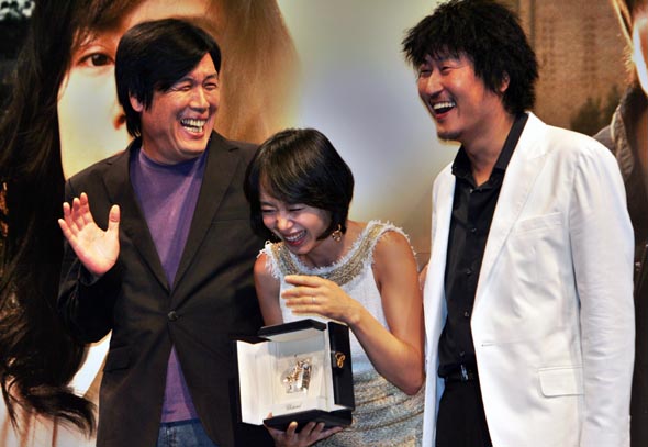 제60회 칸 국제영화제에서 이창동 감독(왼쪽)의 영화 <밀양>으로 여우주연상을 탄 영화배우 전도연(가운데)씨와 상대배우 송강호씨가 30일 오후 서울 강남 압구정동 씨지브이에서 열린 기자회견에서 수상패를 들고 취재진을 향해 손을 흔들다 웃음을 터뜨리고 있다. 
이종근 기자 <A href="mailto:root2@hani.co.kr">root2@hani.co.kr</A>