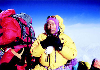 8300m 캠프에서 에베레스트 정상을 배경으로 포즈를 취하고 있는 김재수 대장.