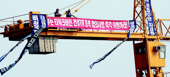 <b>건설노조, 크레인 농성</b> 전국건설노동조합 타워크레인분과 노조원 5명이 26일 오후 서울 마포구 공덕동 이수건설 브라운스톤 아파트 공사장에서 높이 70m의 타워크레인 2개를 점거해 농성하고 있다. 타워크레인분과 노조원들은 법정 노동시간 준수, 비정규직 철폐, 타워크레인의 건설기계 등록 등을 요구하며 지난 4일부터 전면파업을 벌이고 있다. 김명진 기자 littleprince@hani.co.kr