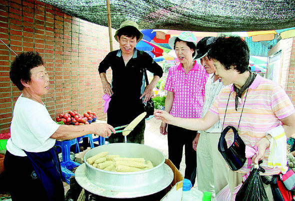 26일 전북 무주군 반딧불장터에서 한 상인이 무주군 산지에서 생산한 무공해 청정 찰옥수수를 손님들에게 팔고 있다. 무주군 제공