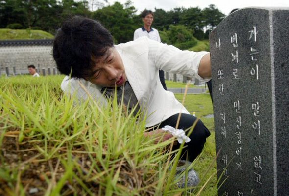 영화 `화려한 휴가‘에 출연했던 영화배우 박철민이 12일 오전 광주 북구 운정동 국립 5.18민주묘지에서 자신의 고교 선배(조대부고)인 고(故) 김부열의 묘비에 씌인 글을 읽고 있다. (광주=연합뉴스)