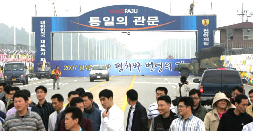 노무현 대통령의 육로 방북 때 남쪽 지역의 외곽 경호를 맡은 경찰관들이 1일 오후 경기 파주시 통일대교에서 경호 관련 모의 훈련을 하고 있다. 뒤쪽으로 통일대교 남단에 ‘2007 남북정상회담 평화와 번영의 길’이라고 적힌 대형 현수막이 걸려지고 있다. 파주/박종식 기자 <A href="mailto:anaki@hani.co.kr">anaki@hani.co.kr</A>