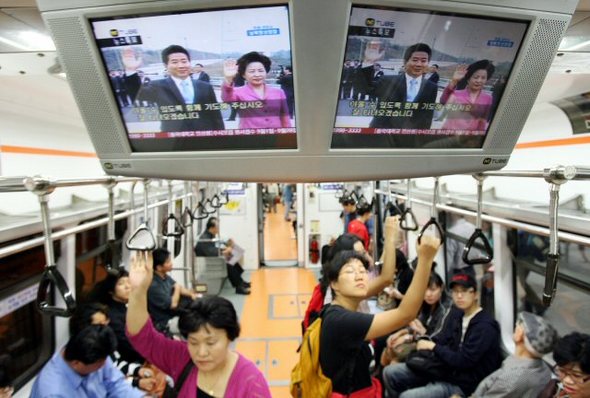 2일 서울 시민들이 지하철에서 제2차 남북정상회담을 위해 노무현 대통령이 군사분계선을 넘는 모습을 화면을 통해 지켜보고 있다. 연합뉴스
