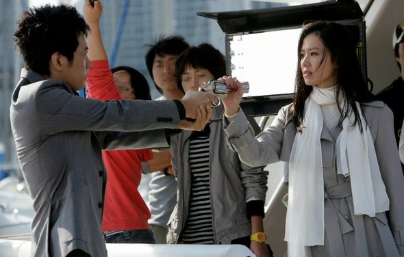 15일 오후 부산 수영만 요트경기장에서 열린 영화 ‘무방비 도시’의 현장공개에서 주연배우 김명민(왼쪽)과 손예진이 연기를 펼치고 있다. (연합뉴스) 15일 오후 부산 수영만 요트경기장에서 열린 영화 ‘무방비 도시’의 현장공개에서 주연배우 김명민(왼쪽)과 손예진이 연기를 펼치고 있다. (연합뉴스)