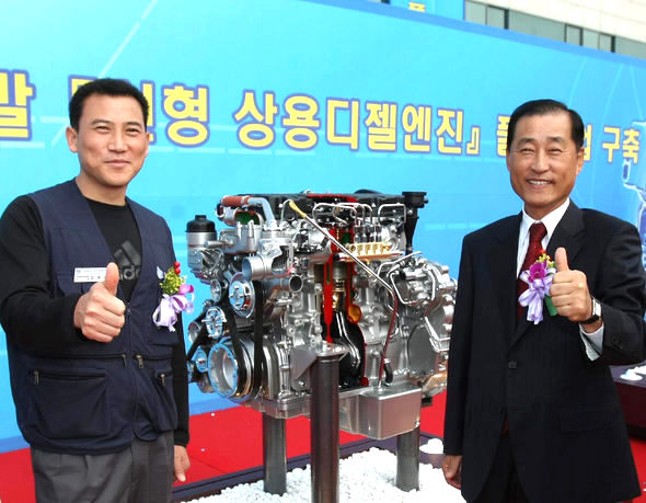 현대자동차가 17일 상용차 전문공장인 전주공장에서 독자기술로 개발한 신형 상용엔진을 발표했다. 김영국 전주공장 공장장(오른쪽)과 김영선 금속노조 현대차 전주지회장이 신형 F3.9 엔진을 배경으로 기념 촬영을 하고 있는 모습. 현대차 제공