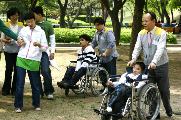 한국동서발전 정태호 사장(오른쪽) 무지개 재활원 자애우들을 데리고 서울 올림픽공원 나들이에 나서고 있다. 동서발전 제공 