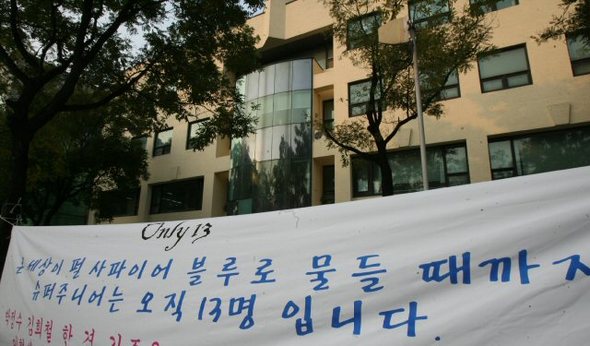 24일 서울 강남구 SM엔터테인먼트 인근에 슈퍼주니어 멤버 추가 영입 반대 팬연합대책위원회 회원 등이 대형 현수막을 걸어놓고 멤버 추가를 반대하고 있다