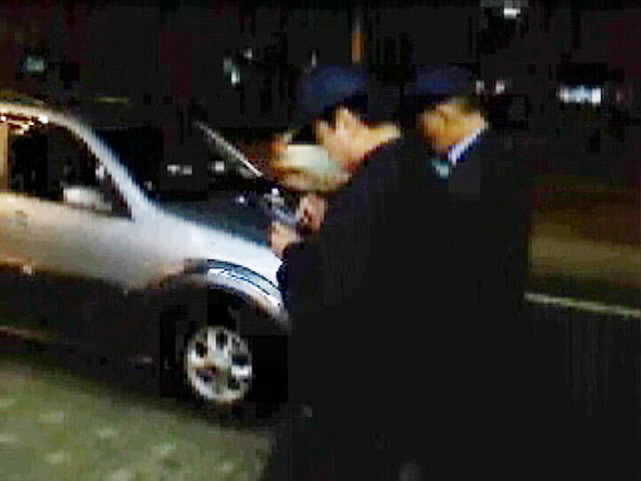 단속요원들이 PDA폰으로 불법주차 차량의 번호판을 기록하고 사진을 찍고 있다