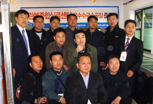 지난 1일 평양직할시 모란봉구역 안 옥수수 국수공장 준공식에서 방북단장인 손덕헌(뒷줄 오른쪽 세번째) 금속노조 현대자동차 부지부장이 준공식을 한 뒤 방북단과 함께 기념사진을 찍고 있다. 뒷줄 오른쪽에서 네번째가 국수공장 지배인인 북한의 엄종철씨.