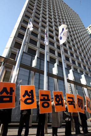 노무현 대통령이 삼성 특검법안을 수용하겠다고 밝힌 27일 오후 서울 중구 태평로 삼성 본관 앞에서 민주노동당 당원들이 ‘삼성공화국 해체’라고 적힌 손팻말을 든 채 대선 선거운동을 하고 있다. 김명진 기자 <A href="mailto:littleprince@hani.co.kr">littleprince@hani.co.kr</A>