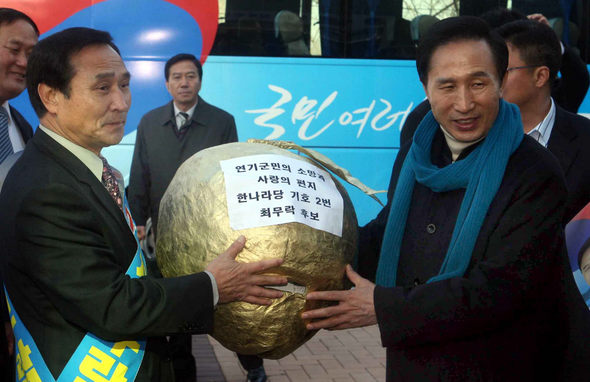 이명박 한나라당 후보가 28일 오전 충남 연기군 금남면 행복도시건설청에서 최무락 한나라당 연기군수 후보한테서 ‘연기군민의 소망과 사랑의 편지’를 담은 복숭아 모형을 받고 있다. 연기/김태형 기자 <A href="mailto:xogud555@hani.co.kr">xogud555@hani.co.kr</A>