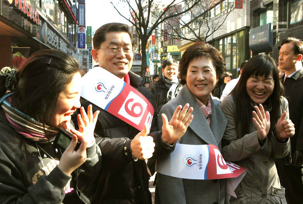 문국현 창조한국당 후보가 28일 오후 서울 명동거리에서 부인 박수애씨(오른쪽 두번째)와 함께 시민들에게 인사하며 손가락으로 기호 6번을 만들어 보이고 있다. 김종수 기자 <A href="mailto:jongsoo@han.co.kr">jongsoo@han.co.kr</A>