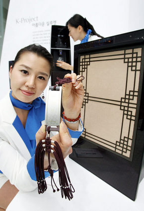 3일 서울 삼성동 코엑스에서 열린 ‘2007 월드 베스트 디자인 교류전’에서 도우미들이 한복 디자이너 이영희씨가 디자인한 노리개 모양의 리모컨과 전통 창틀 모양의 공기청정기를 선보이고 있다. 연합뉴스