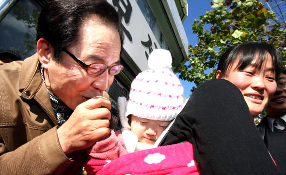 권영길 민주노동당 후보가 14일 오후 경남 진주시 중앙시장 앞 거리에서 열린 유세 중 엄마 등에 업힌 한 아이의 손에 입을 맞추고 있다. 진주/연합뉴스