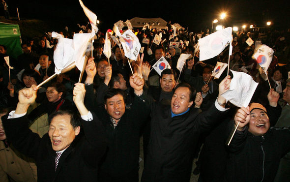 이명박 당선자의 고향인 경북 포항시 흥해읍 덕성1리 주민들과 지지자들이 19일 오후 6시 마을회관 앞에서 각 방송사 출구조사 발표를 지켜보다 이 당선자의 득표율이 압도적인 것으로 나오자 태극기를 흔들며 기뻐하고 있다. 포항/강창광 기자 <A href="mailto:chang@hani.co.kr">chang@hani.co.kr</A>