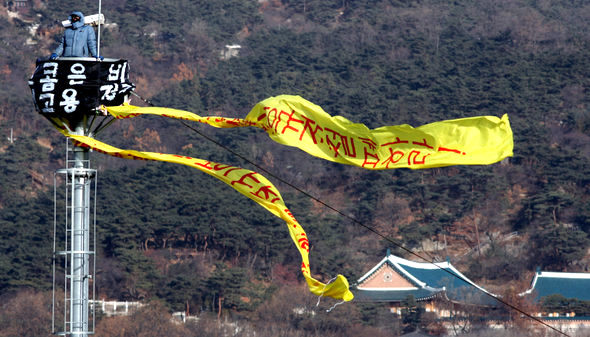 코스콤 비정규직 노동자들이 31일 오전 서울 광화문 네거리 폐쇄회로텔레비전(CCTV) 탑에 올라 ‘비정규직 부당해고 철회’와 ‘정규직 전환’ 등을 요구하며 고공시위를 벌이고 있다. 이종근 기자 <A href="mailto:root2@hani.co.kr">root2@hani.co.kr</A>