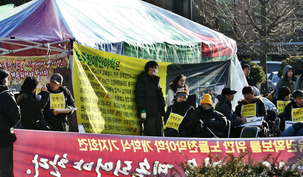 서울지역 성인 장애인을 대상으로 하는 야학인 노들야학 학생들이 2일 오후 서울 대학로 마로니에공원에 세운 비닐 천막에서 올해 개학식을 열고 있다. 김봉규 기자 <A href="mailto:bong9@hani.co.kr">bong9@hani.co.kr</A>