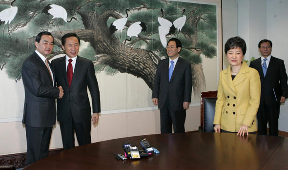 이명박 당선인이 14일 오전 통의동 집무실에서 박근혜 전 한나라당 대표를 미처 보지 못하고 왕이 중국 외교부 부장과 악수한 채 사진을 찍는 동안 박 전 대표가 머쓱한 표정으로 서있다. 사진공동취재단