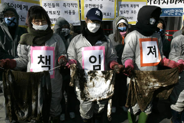 기름 방제복을 입고 장화를 신은 여성환경연대 회원들이 기름으로 흥건한 헝겊을 들고 16일 서울 중구 태평로 삼성그룹 본관 앞에서 서해안 기름유출 사고와 관련해 삼성중공업의 대국민 사과와 손해배상을 요구하는 시위를 하고 있다. 김진수 기자 <A href="mailto:jsk@hani.co.kr">jsk@hani.co.kr</A>