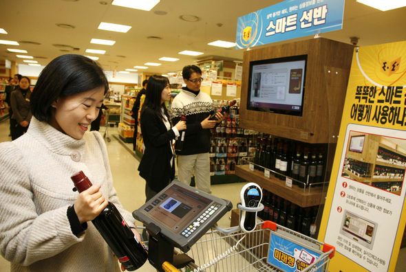 신세계 이마트 수서점에서 고객들이 모니터가 부착된 스마트카트(사진 앞쪽)와 스마트선반(뒤쪽)을 이용해 상품 정보를 살펴보고 있다. 사진 신세계 이마트 제공