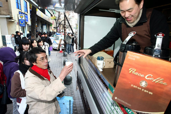 한국YMCA 회원들이 23일 오후 서울 중구 명동에서 지나가는 시민들에게 무료로 피스커피(Peade Coffee)를 나눠주고 있다. 피스커피는 2002년 독립 이후로 경제적 어려움을 겪고 있는 동티모르를 돕기 위해 한국YMCA에서 동티모르 농민들로부터 정당한 가격으로 커피를 사주는 공정무역(fair trade) 캠페인 상품이다. 김명진 기자 <A href="mailto:littleprince@hani.co.kr">littleprince@hani.co.kr</A>