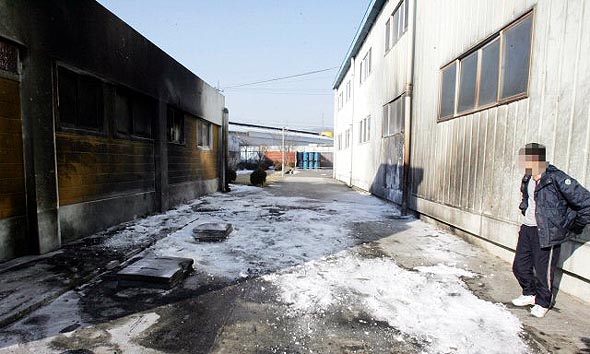 31일 오전 군부대 무인정찰기(UAV) 1대가 추락한 경기도 포천시 선단동의 한 공장에서 직원이 불에 탄 건물을 쳐다보고 있다. 포천/연합뉴스