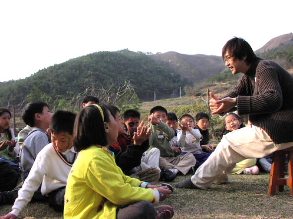 예민은 산골 분교의 아이들과 음악을 나눌 때가 음악인으로 가장 행복했다고 한다. 전북 김제시 화율분교 뒷마당에서 자신의 곡 ‘마술피리’를 수화노래로 가르쳐주고 있는 모습. 사진 아티움오프스 제공