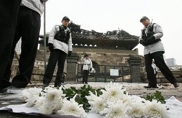 화재로 부분 붕괴된 숭례문 앞에 11일 시민들이 놓고 간 국화꽃이 놓여 있다. 연합뉴스 화재로 부분 붕괴된 숭례문 앞에 11일 시민들이 놓고 간 국화꽃이 놓여 있다. 연합뉴스