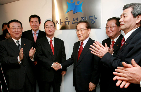 이회창 자유선진당 총재(오른쪽 세번째)와 심대평 대표가 12일 낮 새로 입주한 서울 여의도 당사에서 현판식을 마친 뒤 악수하고 있다. 사진공동취재단