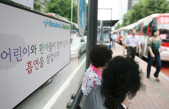 서울시가 지난해 9월부터 시내 모든 버스정류장을 금연구역으로 지정했지만, 잘 지켜지지 않고 있다. 연합뉴스

