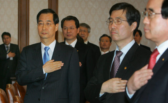 한승수 국무총리 후보에 대한 국회 인준동의안 처리가 연기됨에 따라 참여정부의 한덕수 총리가 27일 오후 서울 세종로 정부중앙청사에서 새 정부 첫 국무회의를 열고 참여정부 국무위원들과 함께 국민의례를 하고 있다. 연합뉴스