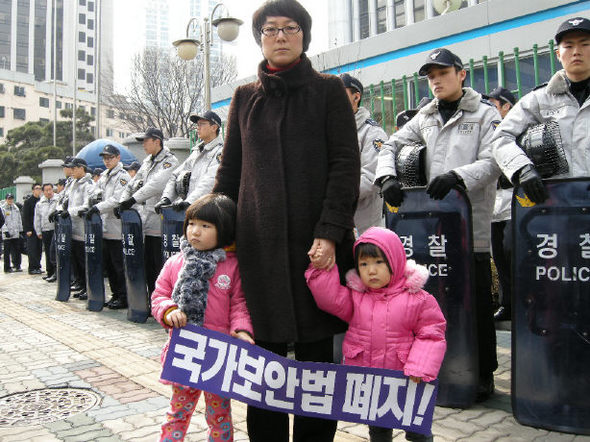 국가보안법 위반 혐의로 10년 수배 끝에 경찰에 연행된 윤기진(35)씨의 부인 황선(36)씨가 두 딸과 함께 28일 오전 서울 서대문구 경찰청 앞에서 보안법 폐지를 요구하는 시위를 벌이고 있다. 남북공동선언실천연대 제공