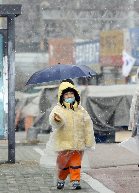 3월 첫번째 일요일인 2일 오전 서울시내 거리에서 할아버지와 함께 산책 나온 아이들이 3월에 내린 눈이 신기한 듯 손을 내밀어 눈을 만져보고 있다. 연합