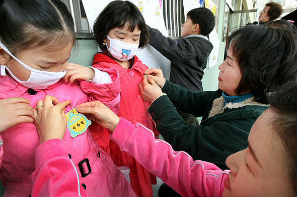3일 경남지역에 황사주의보가 내려진 가운데 마산시 양덕초등학교 입학식에 참석한 아이들이 황사를 피하기 위해 마스크를 쓴채 첫 명찰을 달고 있다. 마산/연합뉴스
