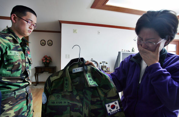 4일 오전 서울 송파구 송파동 박형진 중령의 집에서 부인 신난수(오른쪽)씨가 군복무 중 사고 소식을 듣고 휴가를 나온 아들과 함께 박 중령의 군복을 보며 눈물을 흘리고 있다. 이종근 기자 <A href="mailto:root2@hani.co.kr">root2@hani.co.kr</A>