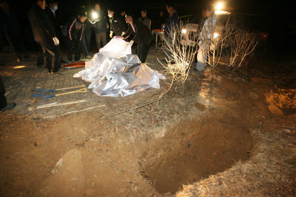 11일 새벽 전남 화순군 동면 청궁리의 한 교회 묘지에서 발견된 김아무개(46·여)씨 일가족 네 명의 주검을 경찰이 수습하고 있다. 화순/연합뉴스
