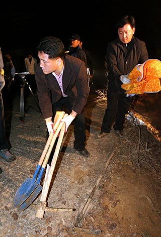 11일 새벽 전남 화순군 동면 청궁리의 한 공동묘지에서 실종된 서울 마포의 김모(46.여)씨 일가족 4명이 숨진채 발견돼 경찰이 범행에 사용한 것 으로 추정되는 연장과 시신을 수습하고 있다. 화순/연합뉴스