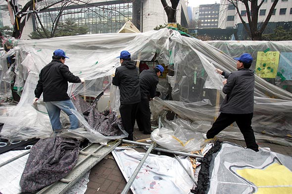 코스콤 비정규직 노조원들이 증권선물거래소 앞길에서 지난해 7월부터 182일동안 비정규직 철폐를 요구하며  농성을 벌이던 천막들이 11일 새벽 용역업체 직원들에 의해 강제로 철거되고 있다.탁기형 선임기자 khtak@hani.co.kr