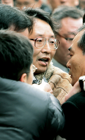 석궁 사건이 발생한 지 1년이 넘었지만 여전히 이를 둘러싸고 여러 가지 의혹들이 제기되고 있다. 사진은 지난해 1월17일 석궁 사건을 일으킨 김명호 전 성균관대 교수가 서울동부지법 앞에서 취재진에게 둘러싸여 있는 모습. (사진/ 연합)