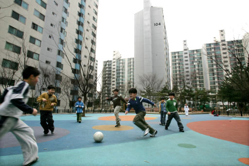 아파트 단지 놀이터에서 축구를 하는 어린이들 모습.