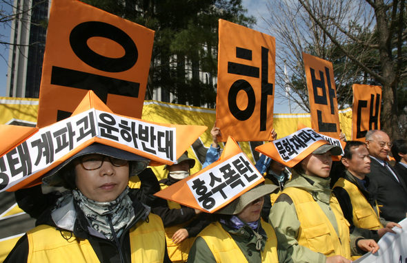 경부운하 예정지 550㎞를 돌아 본 녹색연합 회원들이 21일 오전, 서울 세종로 정부중앙청사 앞에서 운하건설을 반대하는 구호가 적힌 종이 모자를 쓴 채 ‘녹색순례 보고 및 운하백지화를 위한 기자회견’을 열고 있다. 김진수 기자 <A href="mailto:jsk@hani.co.kr">jsk@hani.co.kr</A>