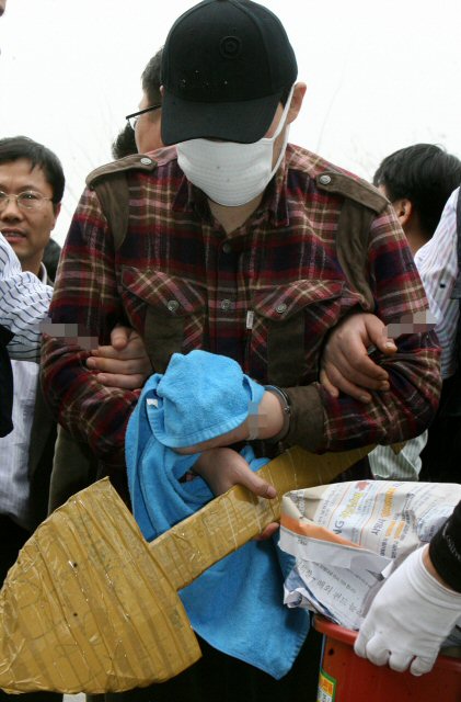안양 초등생 유괴, 살인 피의자인 정씨의 현장검증이 22일 오후 진행돼 정씨가 매장도구를 들고 차에서 내리고 있다. (수원=연합뉴스)