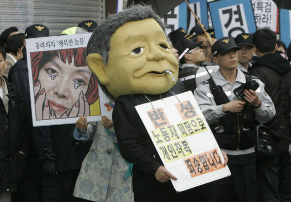 이건희 삼성 회장의 부인 홍라희씨가 조준웅 특검에 소환된 2일 오후 서울 한남동 특검 사무실 앞에서 삼성에스디아이(SDI) 해직 노동자들이 이 회장 얼굴을 본뜬 탈을 쓴 채 삼성이 비자금으로 값비싼 미술품을 사들였다고 주장하며 시위를 벌이고 있다.